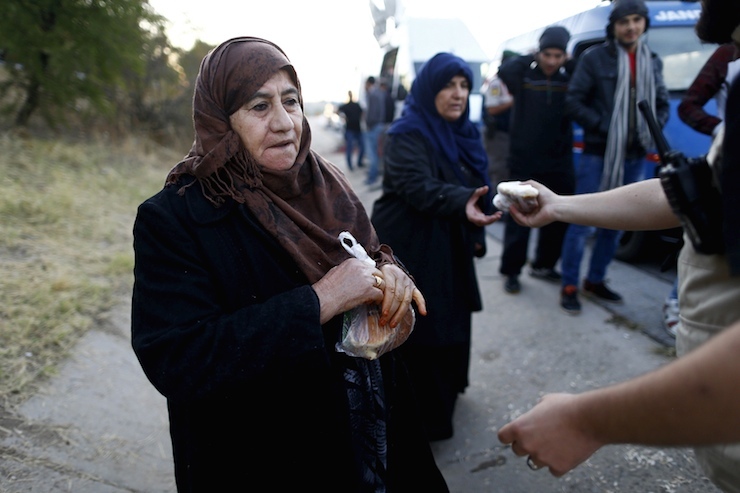 Syrian migrants queue to get food on the side of a highway near Edirne as they rest from their travel towards the Greece border