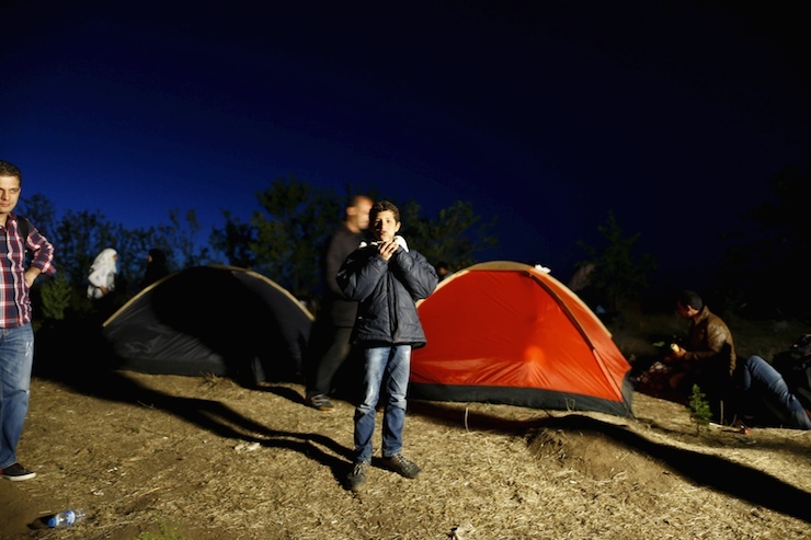 A Syrian migrant walks in front of tents as migrants rest while making their way towards the Greek border, on a road near Edirne, Turkey, September 15, 2015. Turkey stopped hundreds of people, mainly Syrians, from traveling towards its land border with Greece, a possible new front in the migrant crisis. Gendarmes threw up barricades near the border city of Edirne, around 17 km (10 miles) by road from the Greek border, as hundreds of people there thronged the main highway. Others took to surrounding hills in a bid to reach the frontier. REUTERS/Osman Orsal