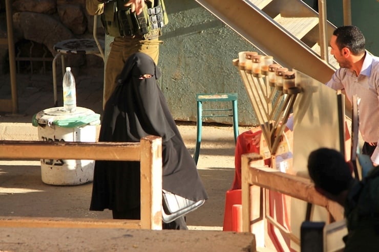 Israeli soldier aims hs rifle at woman said to be 19-year-old Palestinian student Hadeel al-Hashlamun, before she was shot and killed later by Israeli troops, at Israeli checkpoint in occupied West Bank city of Hebron