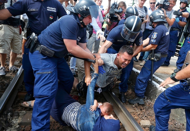 Hungarian policemen detain migrants on the tracks as they wanted to run away at the railway station in the town of Bicske, Hungary, September 3, 2015. A camp for refugees and asylum seekers is located in Bicske. REUTERS/Laszlo Balogh