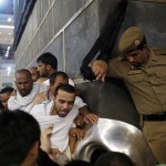 Muslim pilgrims touch and kiss the al-Hajr al-Aswad “Black Stone” at the Grand Mosque on the first day of Eid al-Adha in the holy city of Mecca during the annual haj pilgrimage