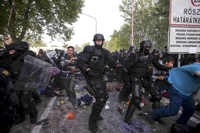Hungarian riot police fight migrants at the border crossing with Serbia in Roszke, Hungary September 16, 2015. Serbia on Wednesday condemned Hungary's use of water cannon and tear gas against migrants on their border, saying Hungary had "no right" to do so, the Serbian state news agency Tanjug reported. REUTERS/Marko Djurica TPX IMAGES OF THE DAY