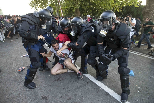 Hungarian riot police fight migrants at the border crossing with Serbia in Roszke