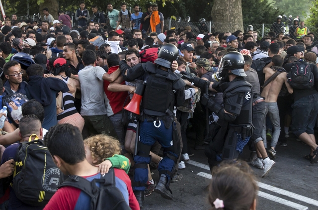 Hungarian riot police fight migrants at the border crossing with Serbia in Roszke, Hungary September 16, 2015. Hungarian police fired tear gas and water cannon at protesting migrants demanding they be allowed to enter from Serbia on Wednesday on the second day of a border crackdown. REUTERS/Marko Djurica