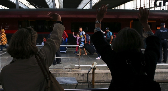 Wellwishers wave to migrants arriving to the main railway station in Munich, Germany September 5, 2015. Austria and Germany threw open their borders to thousands of exhausted migrants on Saturday, bussed to the Hungarian border by a right-wing government that had tried to stop them but was overwhelmed by the sheer numbers reaching Europe's frontiers. REUTERS/Michael Dalder