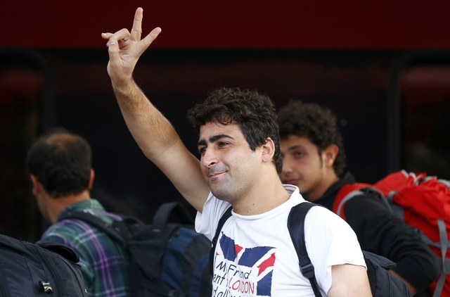A migrant gestures after arriving by train to the main railway station in Munich, Germany September 5, 2015. Austria and Germany threw open their borders to thousands of exhausted migrants on Saturday, bussed to the Hungarian border by a right-wing government that had tried to stop them but was overwhelmed by the sheer numbers reaching Europe's frontiers. REUTERS/Michael Dalder