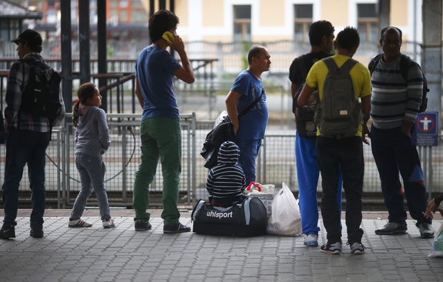 Migrants stand on a platform at the railway station in the town of Gyor