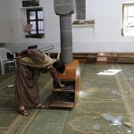 Houthi militant checks shoes inside the al-Balili mosque after two bombings hit the mosque in Yemen's capital Sanaa