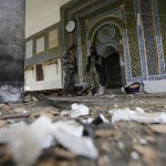 Houthi militants stand inside the al-Balili mosque after two bombings hit the mosque in Yemen's capital Sanaa
