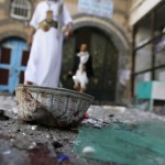 People walk past a headgear lying on the ground at the al-Balili mosque after two bombings at the mosque in Yemen's capital Sanaa