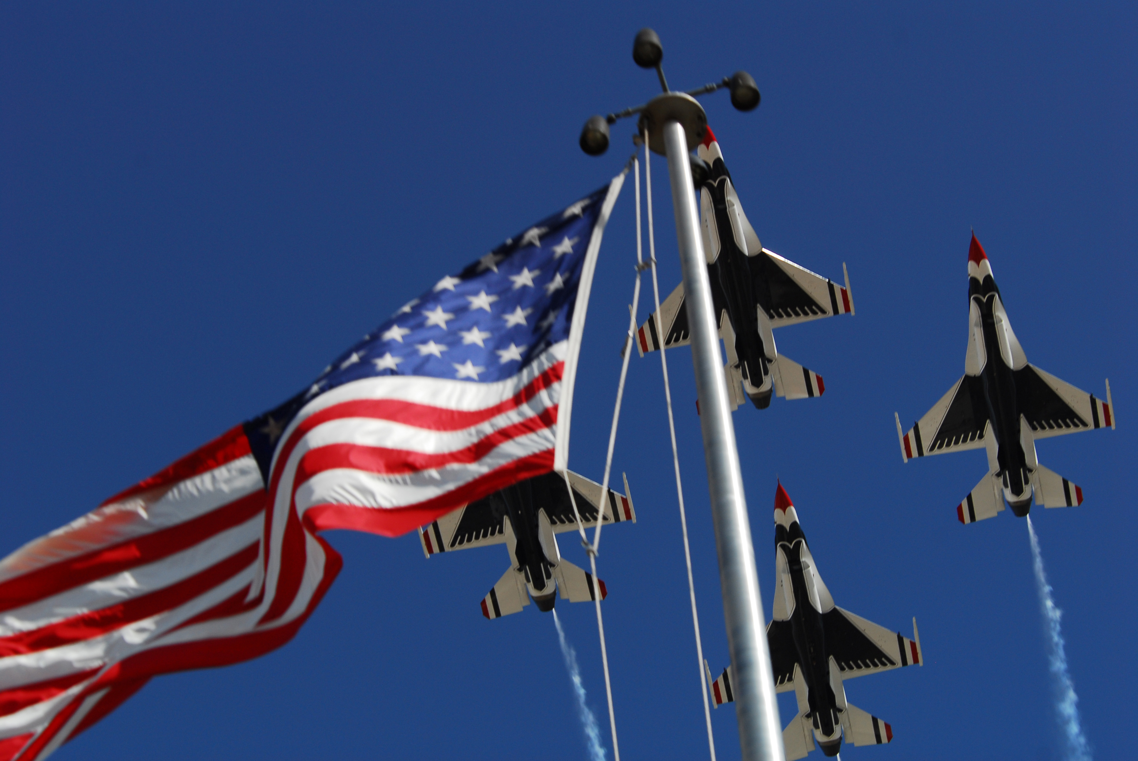 The U.S. Air Force Thunderbird Aerial Demonstration Team?s F-16 Fighting Falcons fly over the base flag pole during their demonstration in the Desert Air Show at Luke Air Force Base, Ariz., March 21, 2009. (U.S. Air Force photo by Airman 1st Class Tracie Forte/Released)