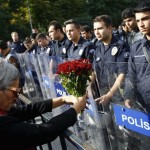A demonstrator holds flowers before a police barricade during a commemoration for the victims of Saturday's bomb blasts in the Turkish capital, in Ankara