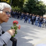 A demonstrator holds flowers near a police barricade during a commemoration for the victims of Saturday's bomb blasts in the Turkish capital, in Ankara