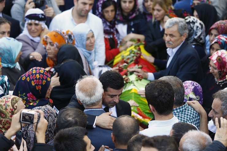 Demirtas hugs a family member of a victim of Saturday's bomb blasts during a funeral ceremony in Istanbul