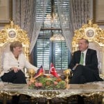 Handout shows Turkish President Erdogan listening to German Chancellor Merkel during their meeting in Istanbul