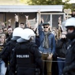 Riot police separate pro-migration protesters from anti-migration protesters in Helsinki