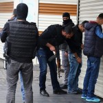 Plainclothes police officers perform a body search during an operation in Sur district, where an unidentified gunman on Saturday killed a top Kurdish lawyer, in the Kurdish-dominated city of Diyarbakir