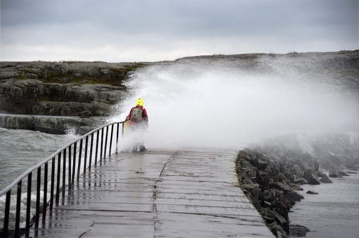 A woman is hit by a wave caused by stormy winds in Helsinki