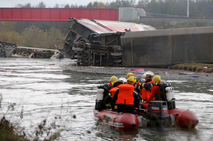 Rescue workers search the wreckage of a test TGV train that derailed and crashed in a canal outside Eckwersheim near Strasbourg