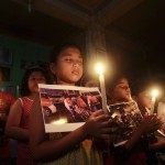 Children hold candles as they pray during a vigil to show solidarity with the victims of the attacks in Paris, at a dance school in Agartala