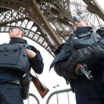 Police take up position under the Eiffel Tower the morning after a series of deadly attacks in Paris