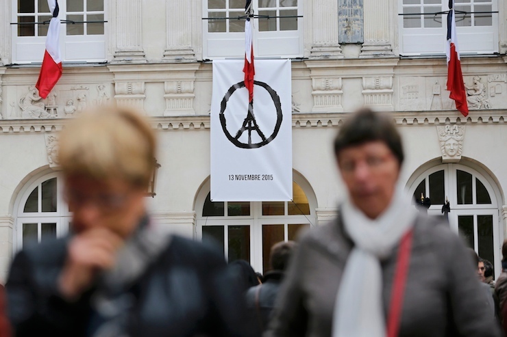 A banner with the drawing "Peace for Paris" by French artist Jean Jullien is hung as people observe a minute of silence at the Nantes city hall to pay tribute to the victims of the series of deadly attacks on Friday in the French capital