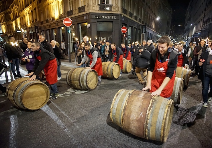 Men roll barrels of Beaujolais Nouveau wine for the official launch of the 2015 vintage in the center of Lyon