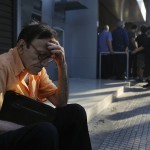 Giorgos, a 77-year-old pensioner from Athens, sits outside a branch of the National Bank of Greece as he waits along with dozens of other pensioners, hoping to get their pensions in Athens