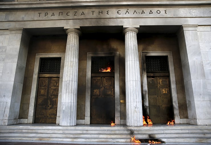 Fire caused by petrol bombs thrown by youths is seen at the building of Greece's central bank following brief clashes between police and protesters during a 24-hour general strike in central Athens, Greece November 12, 2015. Striking Greeks took to the streets on Thursday to protest austerity measures, setting Alexis Tsipras' government its biggest domestic challenge since he was re-elected in September on a promise to cushion the impact of economic hardship. The fire was extinguished without causing serious damage. REUTERS/Yannis Behrakis TPX IMAGES OF THE DAY