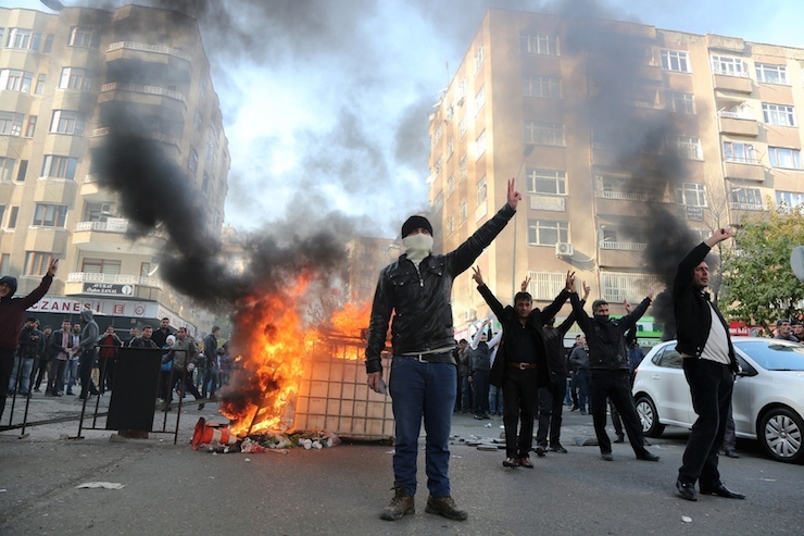 Demonstrators gesture during a protest against the curfew in Sur district, in the southeastern city of Diyarbakir