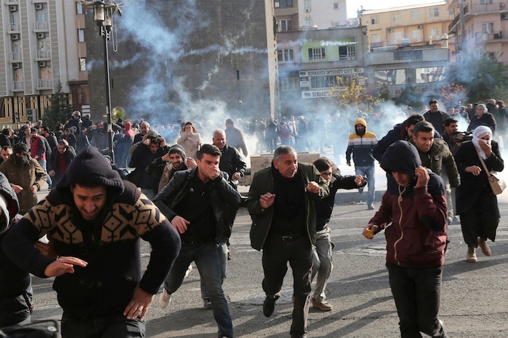 Riot police fire tear gas to disperse demonstrators during a protest against the curfew in Sur district, in the southeastern city of Diyarbakir, Turkey