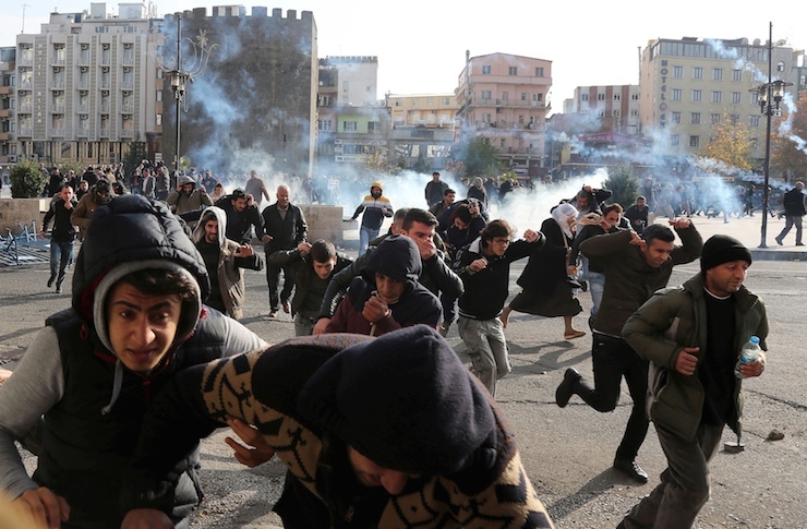 Riot police fire tear gas to disperse demonstrators during a protest against the curfew in Sur district, in the southeastern city of Diyarbakir, Turkey