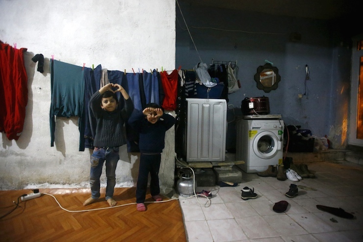 Syrian refugee boys pose as his mother takes part in an interview with Reuters in Istanbul
