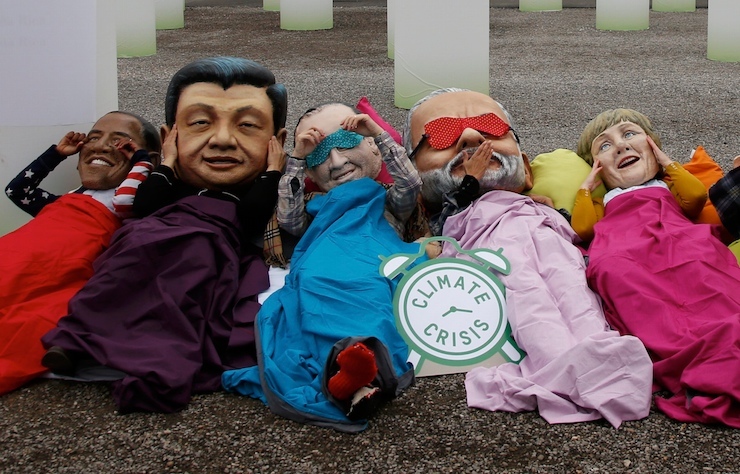 Activists of global anti-poverty charity Oxfam wearing masks depicting some of the world leaders stage a protest outside the venue of the World Climate Change Conference 2015 in Le Bourget, near Paris