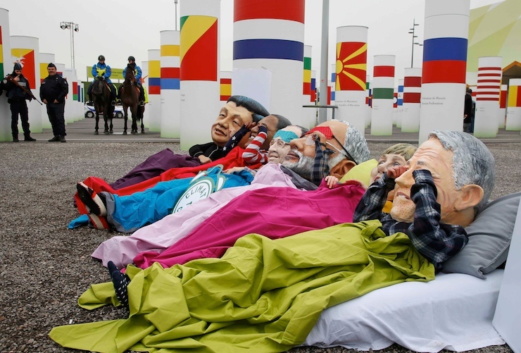 Activists of global anti-poverty charity Oxfam wearing masks depicting some of the world leaders stage a protest outside the venue of the World Climate Change Conference 2015 in Le Bourget, near Paris
