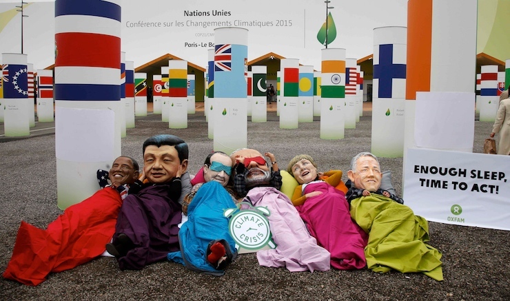 Activists of global anti-poverty charity Oxfam wearing masks depicting some of the world leaders stage a protest outside the venue of the World Climate Change Conference 2015 in Le Bourget, near Paris