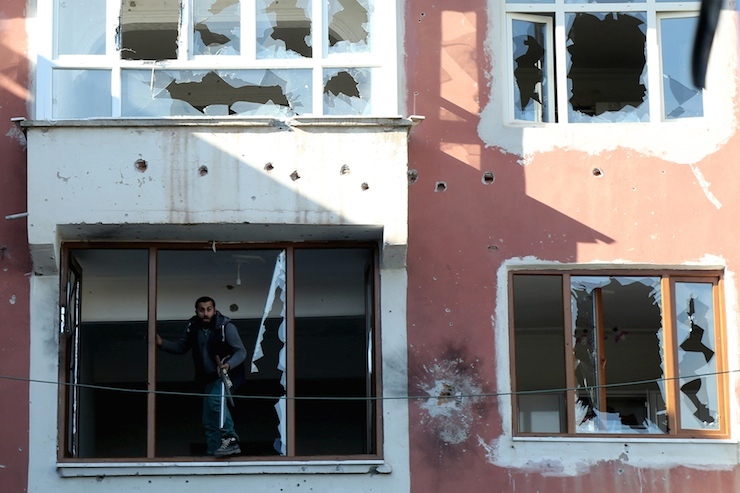 A man looks out of a building which was damaged during the security operations and clashes between Turkish security forces and Kurdish militants, in Sur district of of Diyarbakir, Turkey