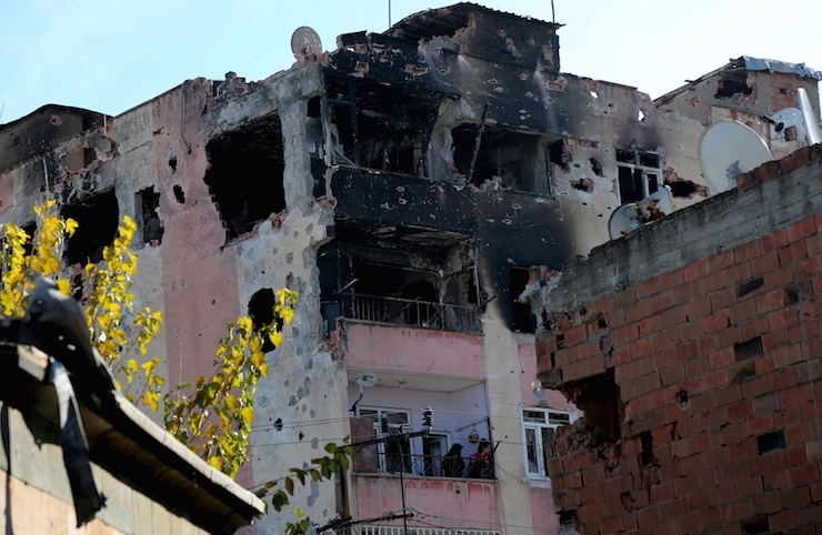 People look out from a building which was damaged during the security operations and clashes between Turkish security forces and Kurdish militants, in Sur district of Diyarbakir, Turkey