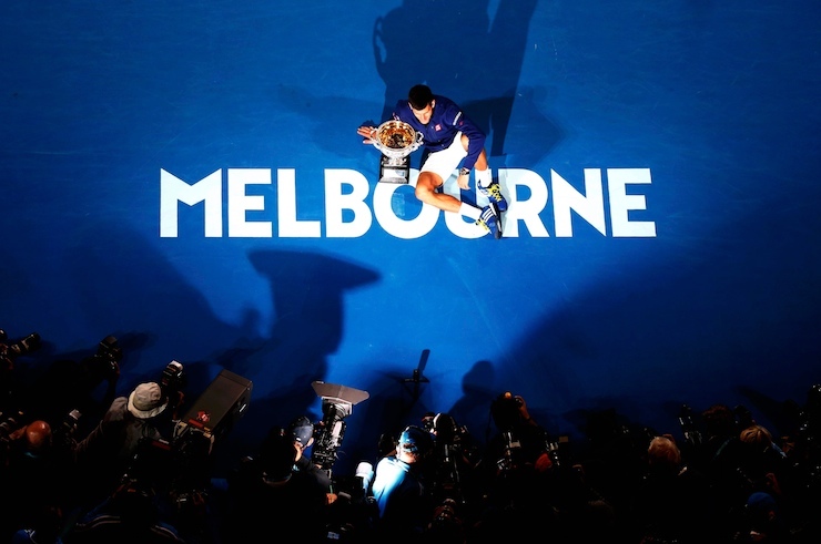 Serbia's Djokovic sits on the court as he celebrates with the men's singles trophy after winning his final match against Britain's Murray at the Australian Open tennis tournament at Melbourne Park