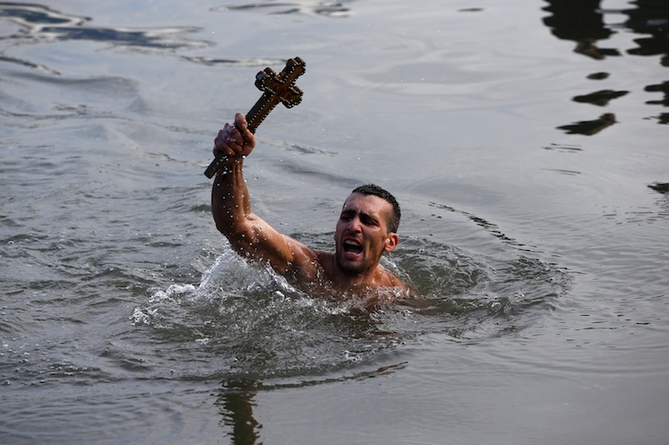 Greek Orthodox faithful Nikolas Solis holds a wooden crucifix in the Golden Horn in Istanbul