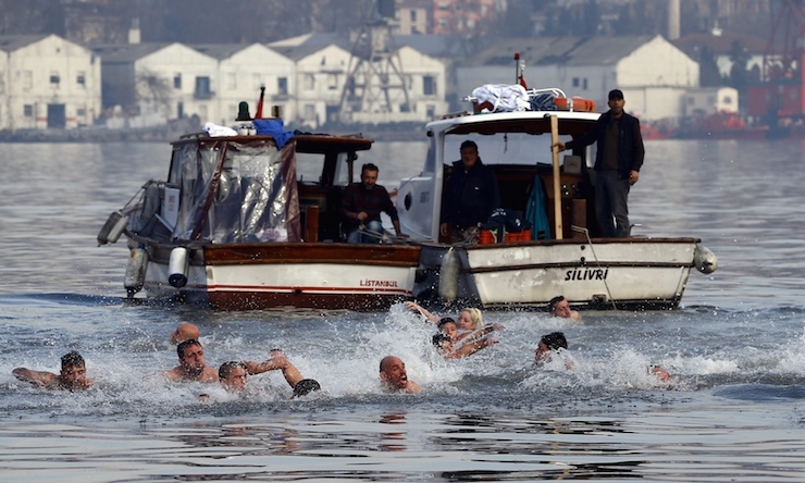 Greek Orthodox faithful swim towards a wooden crucifix in the Golden Horn in Istanbul, Turkey, January 6, 2016. Greek Orthodox faithful swam to retrieve the wooden crucifix thrown by Greek Orthodox Ecumenical Patriarch Bartholomew I into the Golden Horn in Bosphorus during Epiphany Day celebrations. REUTERS/Murad Sezer