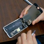 A man tries to repair an iPhone in a repair store in New York
