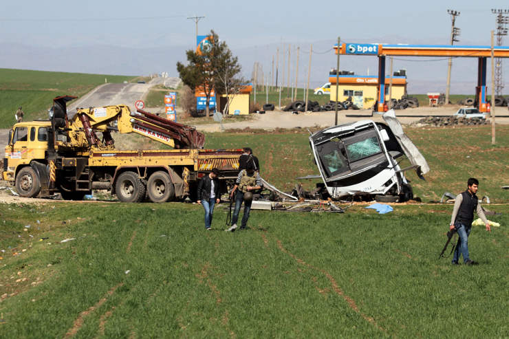 Security officers walk around a damaged military vehicle near Diyarbakir, Turkey February 18, 2016. A bomb detonated by remote control killed seven Turkish security force members travelling in a military vehicle in southeast Turkey on Thursday, security sources said, a day after a car bomb attack in the capital Ankara killed 28 people. REUTERS/Sertac Kayar