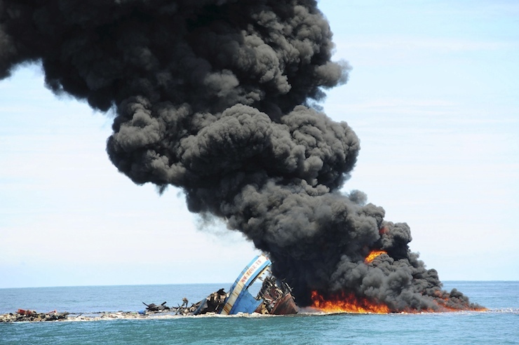 Smoke is seen coming from four of eight confiscated Vietnamese fishing boats destroyed by the government in Mempawah Regency, West Kalimantan, Indonesia