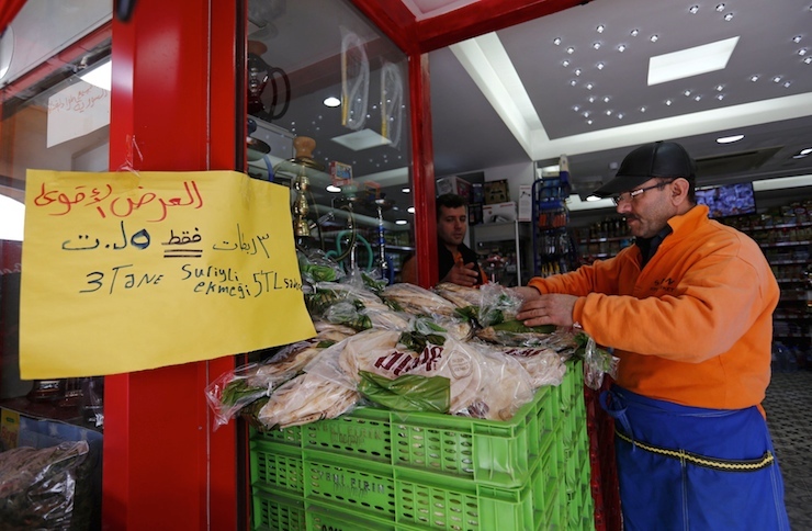 An Arabic sign that reads: "3 Syrian style bread 5 lira" is seen at a market in Istanbul, Turkey February 17, 2016. Turkey's 2.6 million Syrian refugees may be straining the housing and jobs systems, but they're also fuelling economic growth. The world's largest refugee population has had a positive impact on Turkish output, economists and government officials say. It may be partly responsible for an unexpected rise in third-quarter growth and stronger forecasts for 2016 output. Picture taken February 17, 2016. REUTERS/Murad Sezer