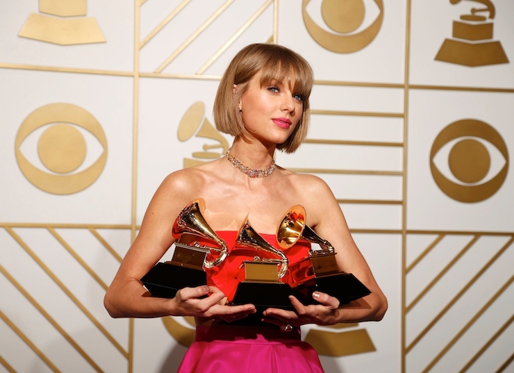Taylor Swift poses with her awards during the 58th Grammy Awards in Los Angeles
