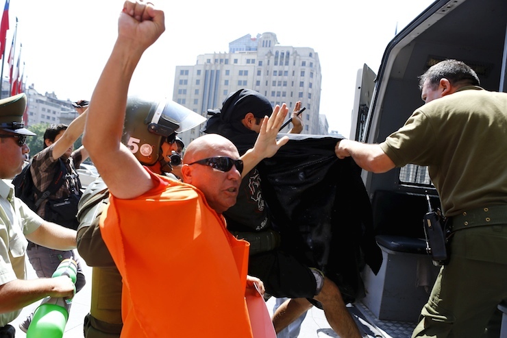 Demonstrators are detained by riot policemen during a protest against Turkish President Tayyip Erdogan's visit, in front of the government house, in Santiago, Chile
