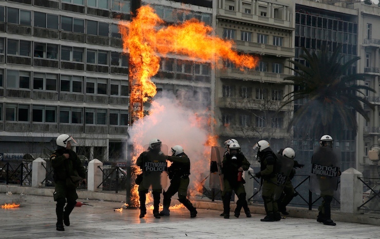 Riot police react to petrol bombs during a 24-hour general strike against planned pension reforms in Athens