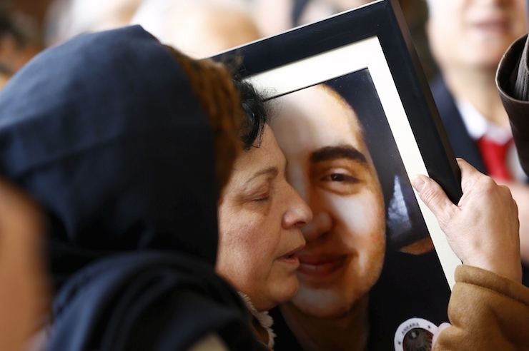 A relative of Elvin Bugra Arslan, one of the victims of Sunday's suicide bomb attack, holds his picture during a funeral ceremony in Ankara