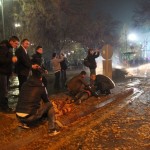 People help an injured person on the ground near the explosion site in Ankara